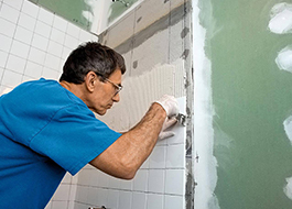 man providing additional services by applying concrete for white bathroom tile