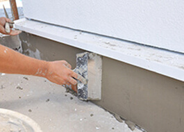 person providing addition services by repairing plaster with short brush